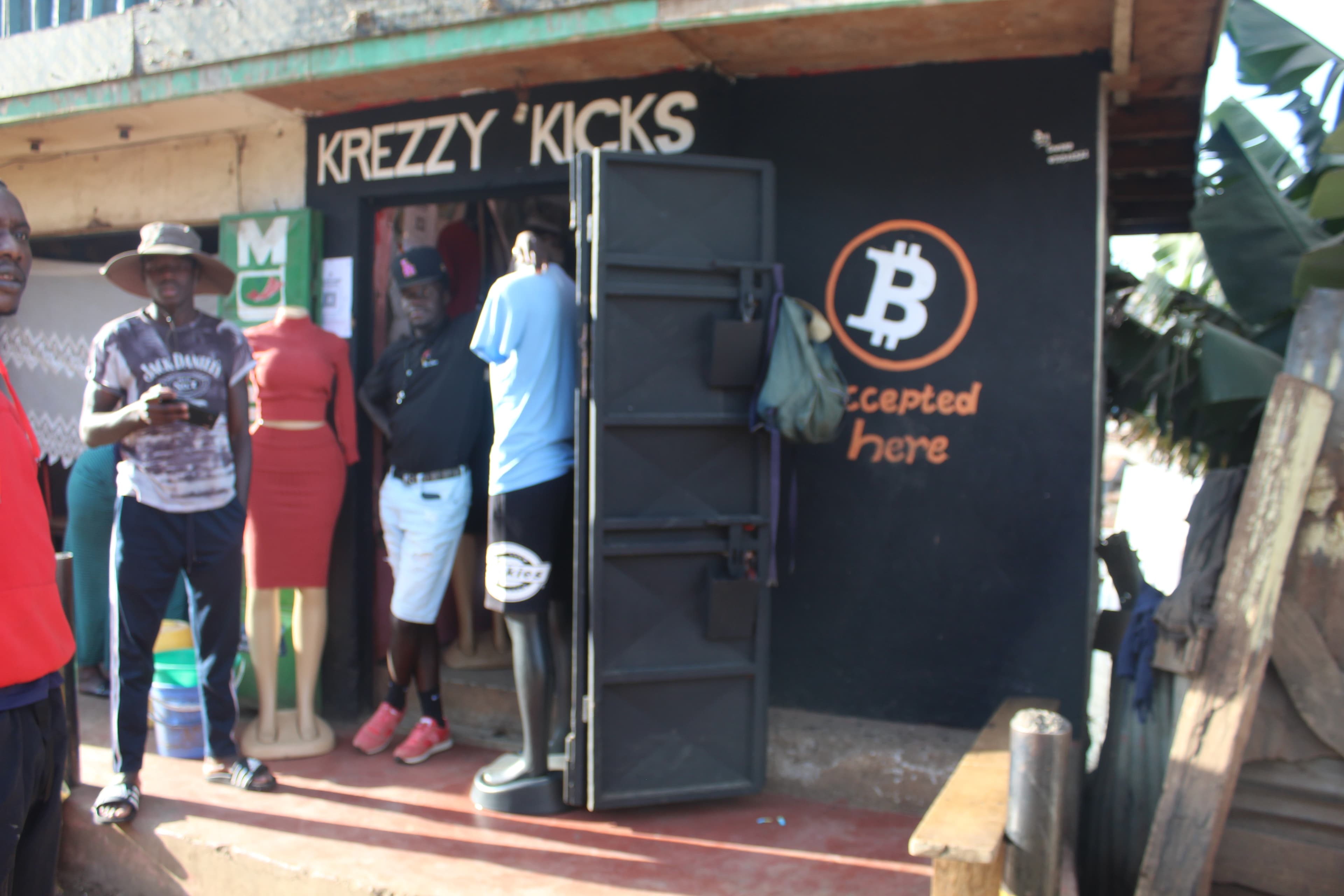 Krezzy Kicks shoe shop in Kibera with Bitcoin accepted here painted in orange on the black door